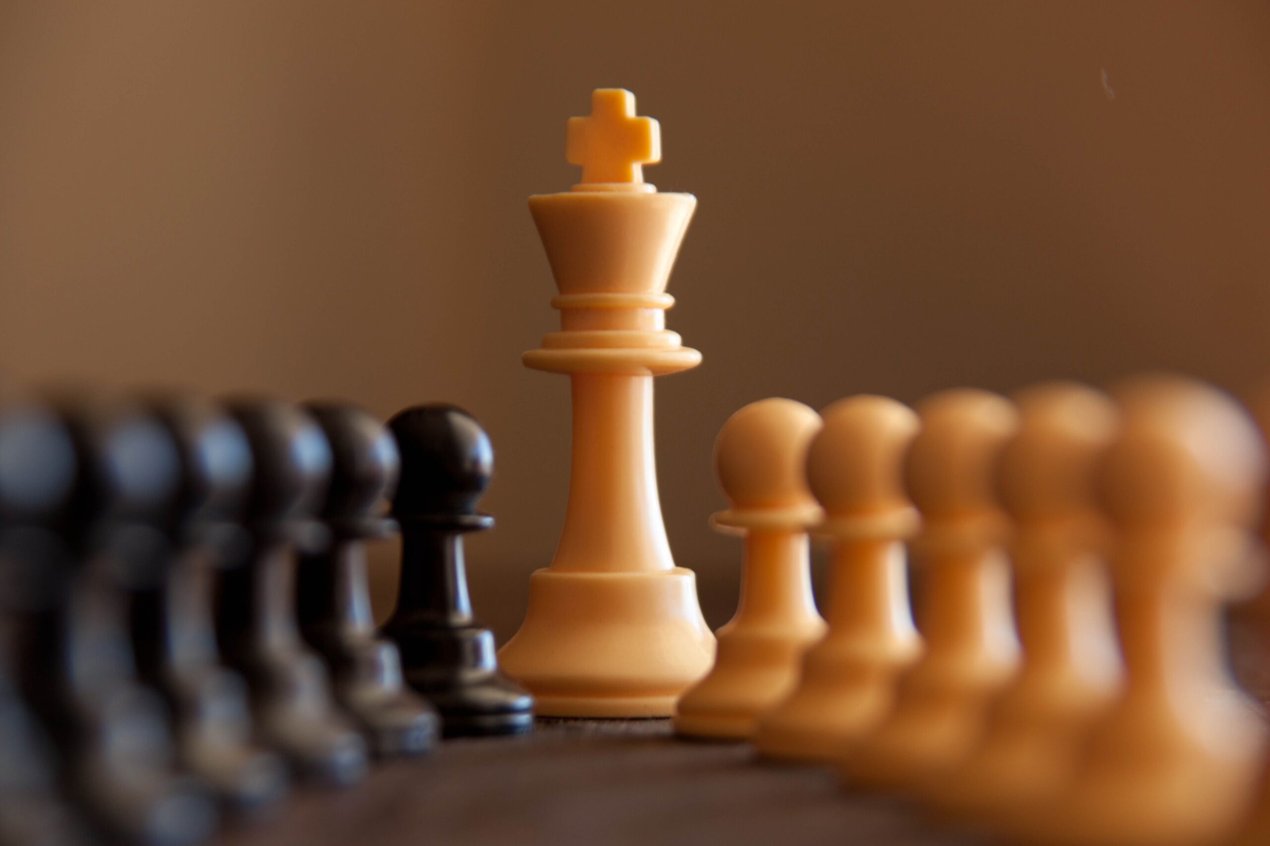 Close-up of chess pieces with king in focus, highlighting strategy and competition.